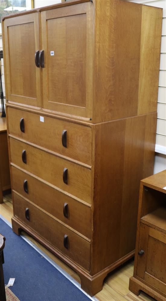 A Gordon Russell oak cupboard, enclosed by a pair of doors over four long drawers W.96.5cm